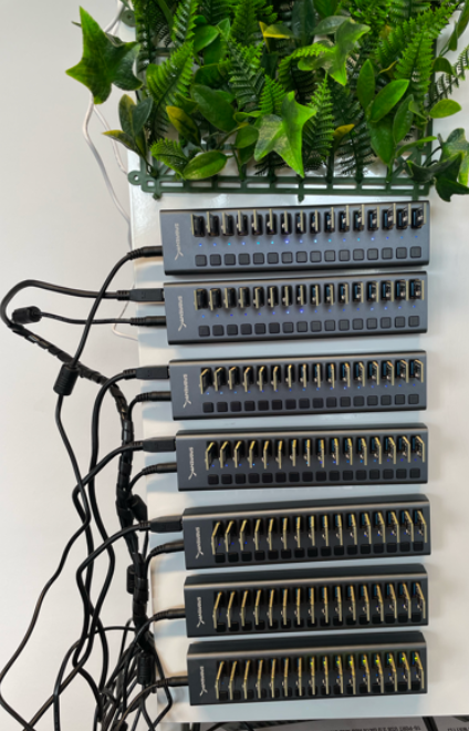 Wall-mounted USB hubs holding 100+ Bluetooth beacon dongles in the testbed